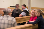 Menschen sitzen in Kirchenbänken